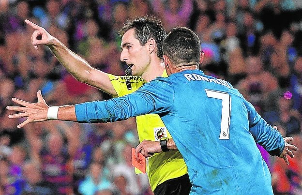 Cristiano Ronaldo protesta a De Burgos Bengoetxea su decisión de expulsarle el domingo en el Camp Nou. :: afp
