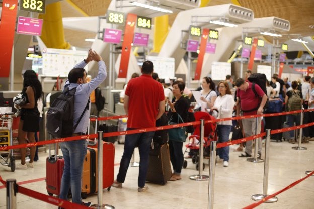 Pasajeros guardan cola para facturar en el aeropuerto de Madrid-Barajas. :: Paco campos / efe