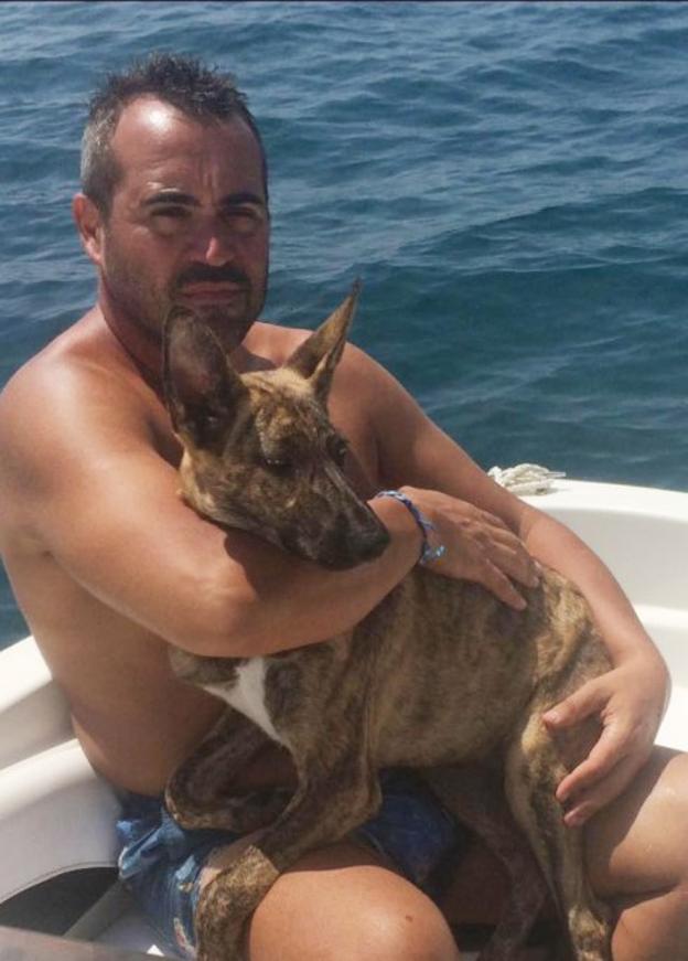 Enrique, uno de sus rescatadores, y la perra en el barco.