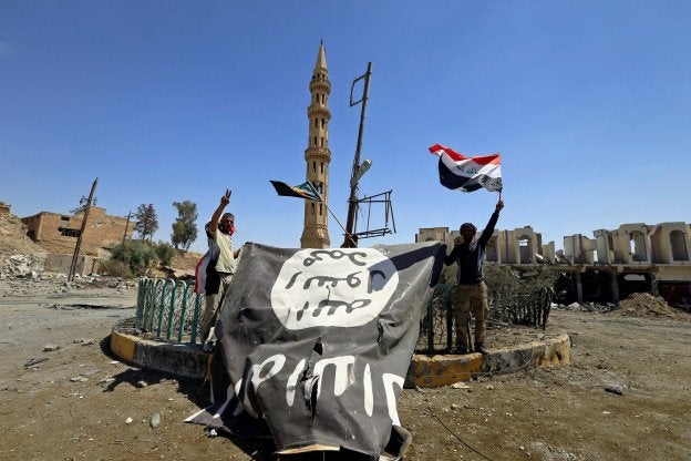 Dos soldados chiíes celebran la victoria en Tal Afar; abajo, el castillo de la ciudad liberado. :: Thaier Al-Sudani / reuters