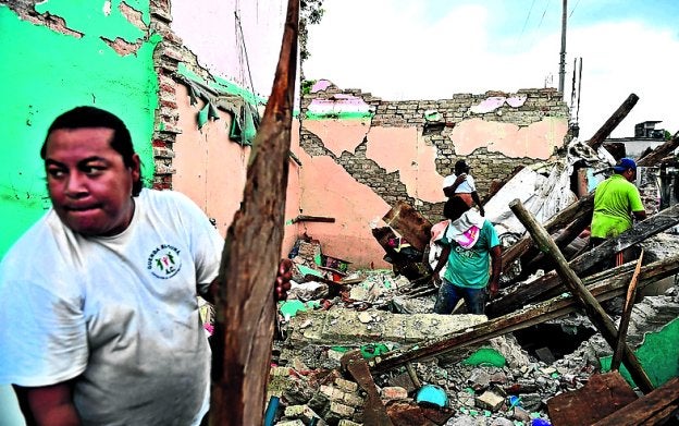 Personas buscan sus pertenencias entre ruinas en Juchitán. :: afp