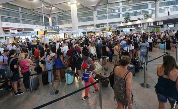 Pasajeros hacen cola ante los mostradores de facturación del aeropuerto de Málaga en una de las jornadas intensas del verano 