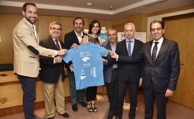 Los organizadores muestran la camiseta solidaria de esta edición que se puede adquirir por 3 euros./Francis Silva