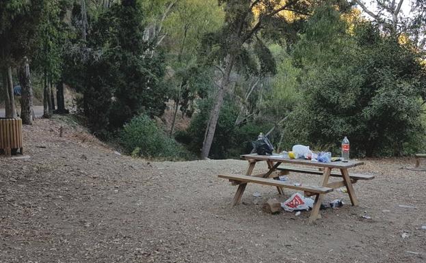 Bolsas de plástico, botellas y papeles en una mesa del monte. /C. S.