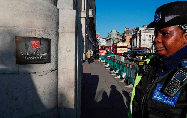 Una policía hace guardia ante la sede de la empresa que gestiona el patrimonio privado de Isabel II. :: R. c./