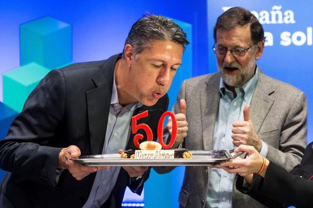 Albiol sopla las velas de su tarta de cumpleaños ayer junto a Rajoy en Lleida. :: Quique García / efe/