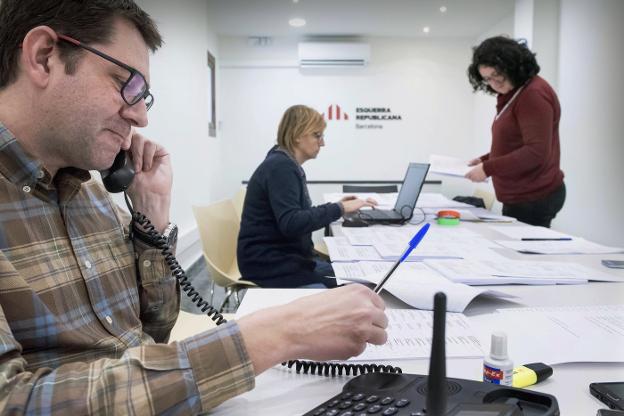 José María Vall atiende al teléfono, mientras Thais Domenech y Elvira Duran repasan varios documentos de trabajo. :: vicens giménez/