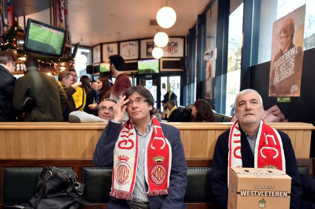 Puigdemont, con la bufanda del Girona, sigue el partido en una cafetería de Bruselas. :: Eric Vidal / reuters/