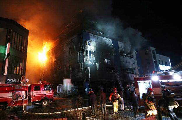 Los bomberos actúan en el edificio incendiado en Jecheon. :: Yonhap / efe/