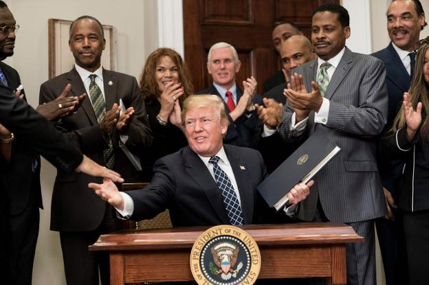 Trump, rodeado de los organizadores del día dedicado al mítico líder antirracista Martin Luther KIng. :: afp/