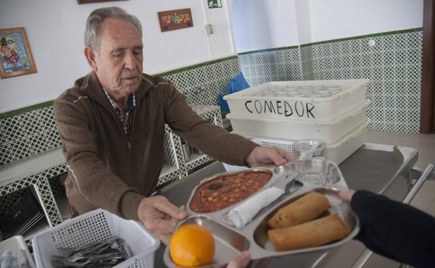 Algunas de las mujeres que colaboran con la asociación preparan bolsas con comida.