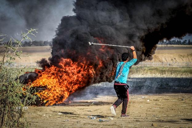 Un palestino lanza piedras con una honda contra los soldados israelíes. :: I. Abu Mustafa / reuters/