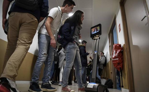 Un robot traslada a través de la pentalla a Lydie, enferma de asma, a su centro escolar. /PHILIPPE DESMAZES (AFP)