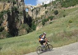 Un cicloturista pasa por delante del Tajo de Ronda, uno de los puntos más emblemáticos de la ruta. :: SUR/