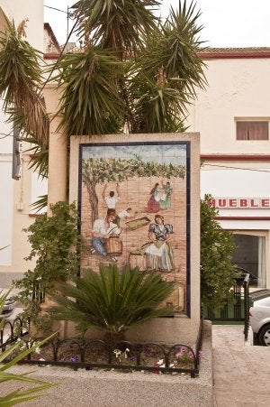 La iglesia de Santa María de Ambrox, restaurada después del incendio de 1993, y la torre del Ayuntamiento, con las laderas de la Sierra de Gádor asomando a la derecha. Un mural recuerda una actividad tradicional, la recogida y envasado de la uva en toneles. ::
FOTOS: ANTONIO ZAMORA GÓNGORA/