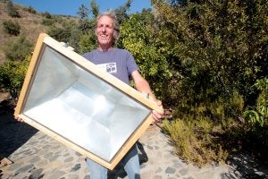 David Chapman muestra uno de los hornos solares que el mismo construye y que vende en 'comunes'. :: ANTONIO SALAS/