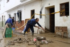 Un vecino de Villanueva del Rosario retira el barro acumulado en la entrada de su casa tras la riada.:: Álvaro Cabrera/