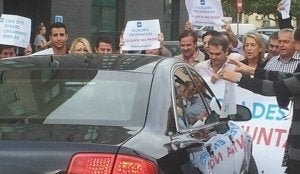 Alcaldes, concejales y cargos del PP intentan obstaculizar la salida del coche oficial de Susana Díaz de un hotel de la capital. :: TWITTER/