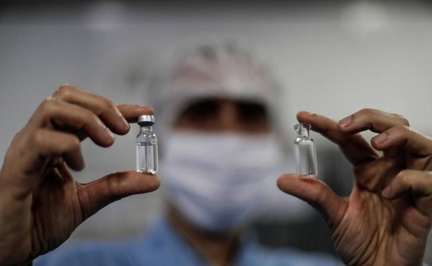 A health worker with two vials of a coronavirus vaccine. /R.C.