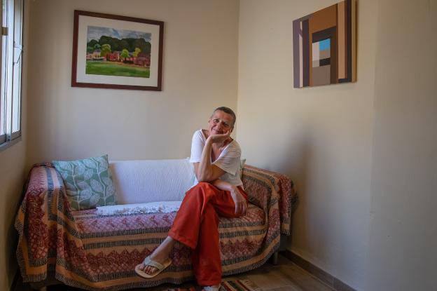 Helen Purdie at her home in Torrox with two of her paintings on the wall behind her. 
