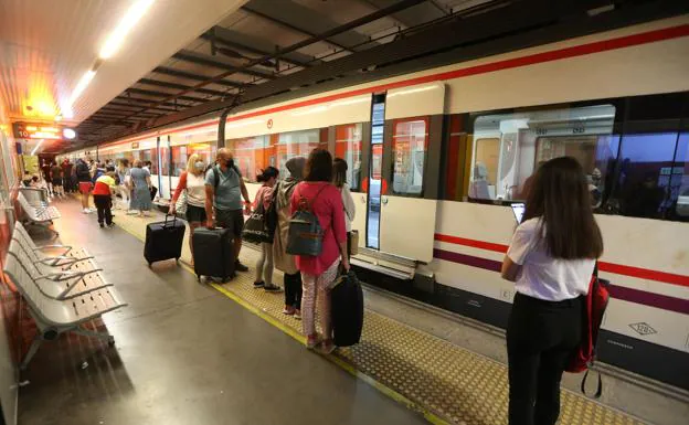 Passengers wait for the train to open its doors. 