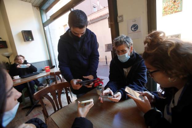 A waiter checks customers' Covid passports in Catalonia this week. / EFE