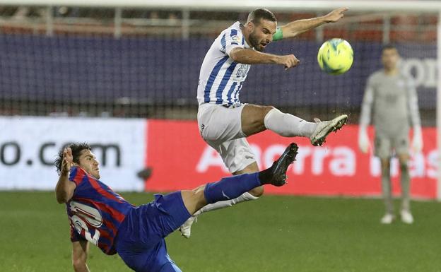David Lombán challenges an Eibar player for the ball. 