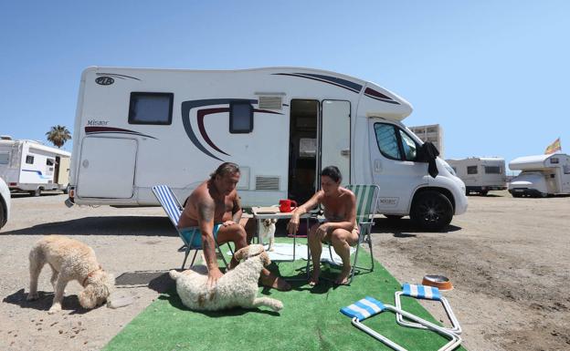 Javier and Mela, with their dogs outside their caravan. 