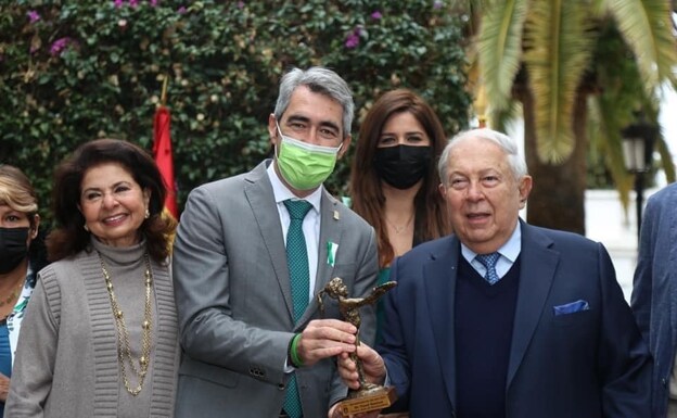Dr Hamied (R) and his wife receive the award from Mayor Víctor Navas. /SUR