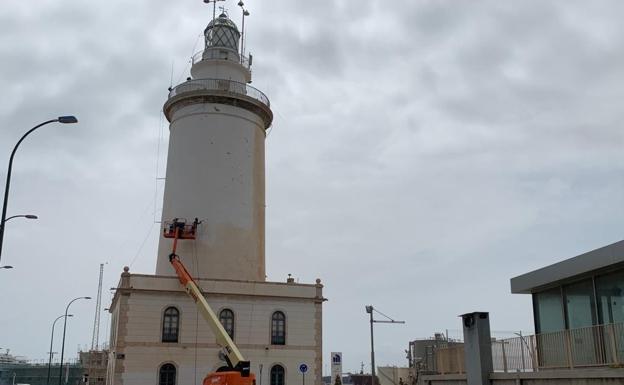 Orange dust is washed off Malaga's lighthouse./SUR