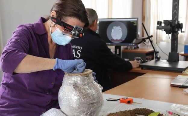 Researchers study the Phoenician funeral urn. 