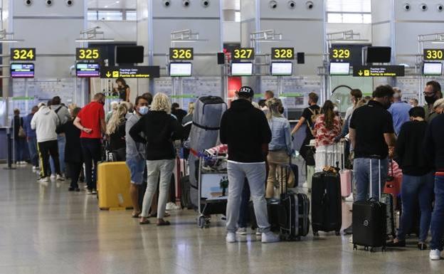 Passengers waiting to check-in at Malaga Airport. 