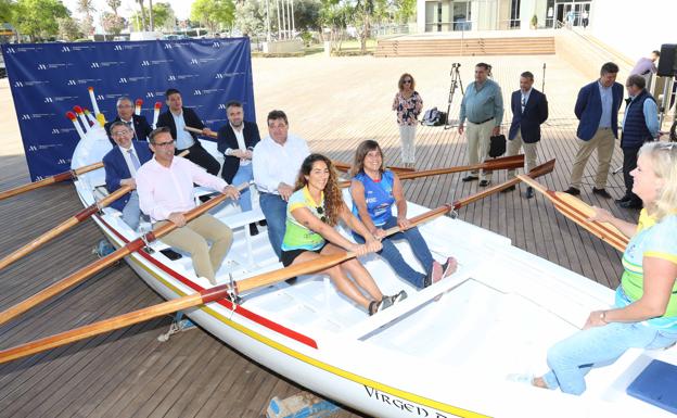 Local representatives and rowers sit in a fishing boat used in the competition. 
