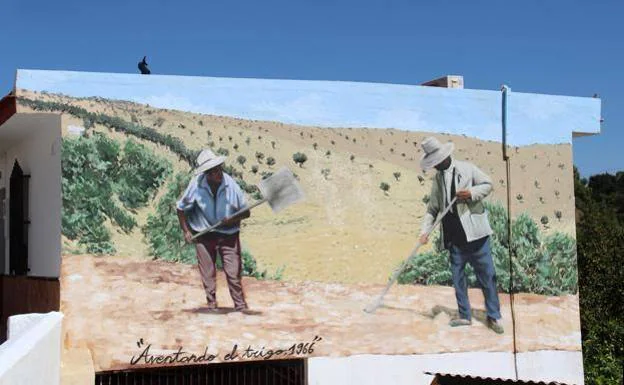 The new mural depicts two land workers threshing wheat. 