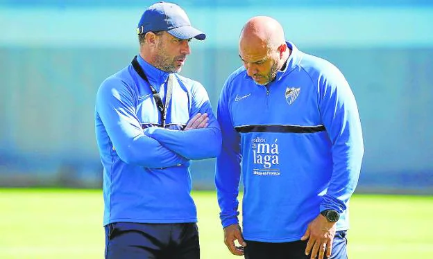 Malaga head coach Pablo Guede talks with his assistant, Francisco Bravo. / MARIANO POZO