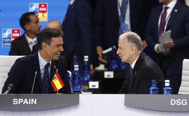 Sánchez talks with a senior Nato official at the summit. The Spanish flag is upside down.