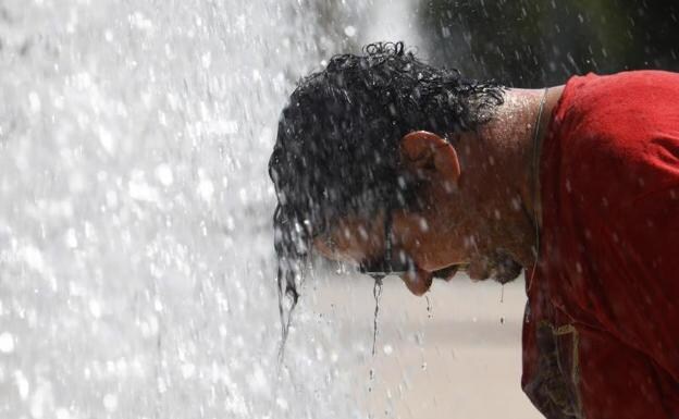 A man cools himself down at a fountain in Cordoba. /EFE