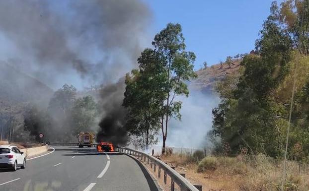 The burning vehicle at the roadside.