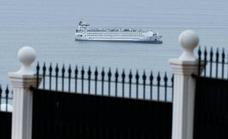 Why has a cargo ship spent all summer at anchor in Malaga bay?