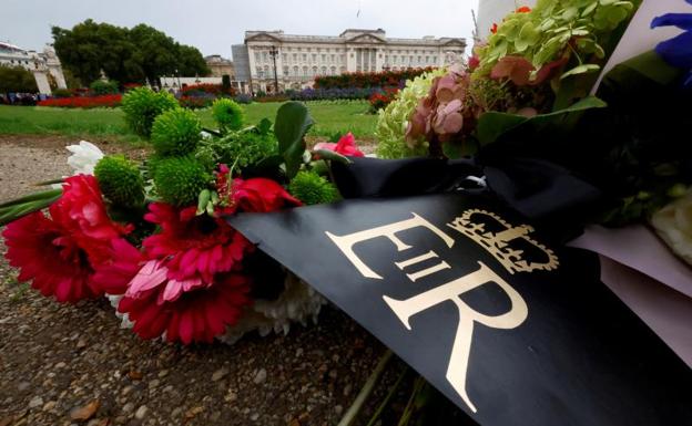 Los tributos florales con la cifra real de la reina Isabel II se ven fuera del Palacio de Buckingham.