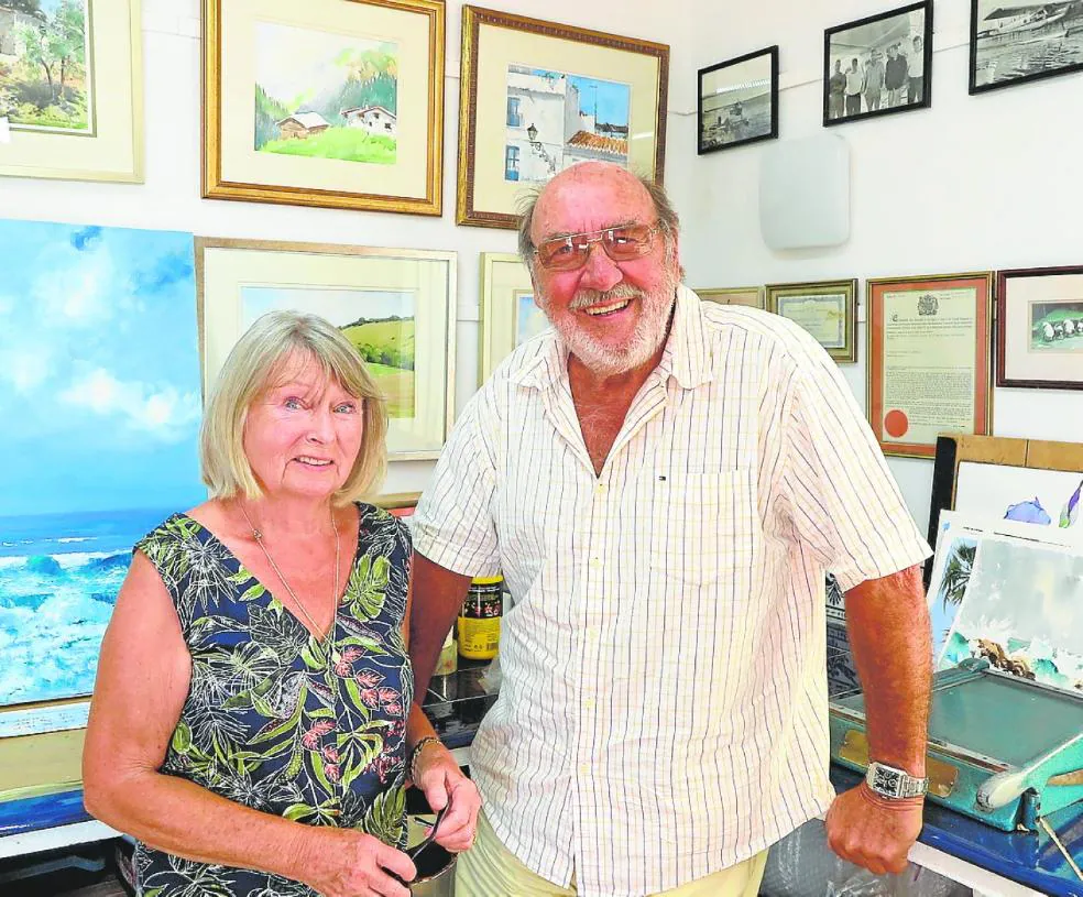 Jane and Andrew Price, in one of the rooms decorated with his paintings. 