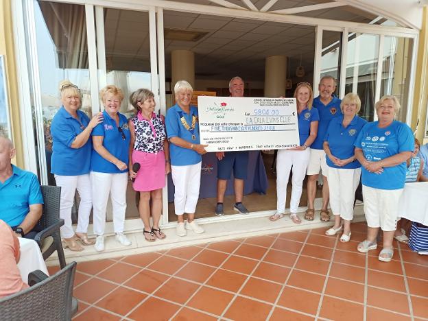 Sue Marshall (3L) hands over the cheque to the Lions. 