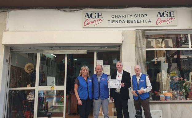 Alan Boardman (Mijas walking tours) hands the cheque to AC officials outside their shop./SUR