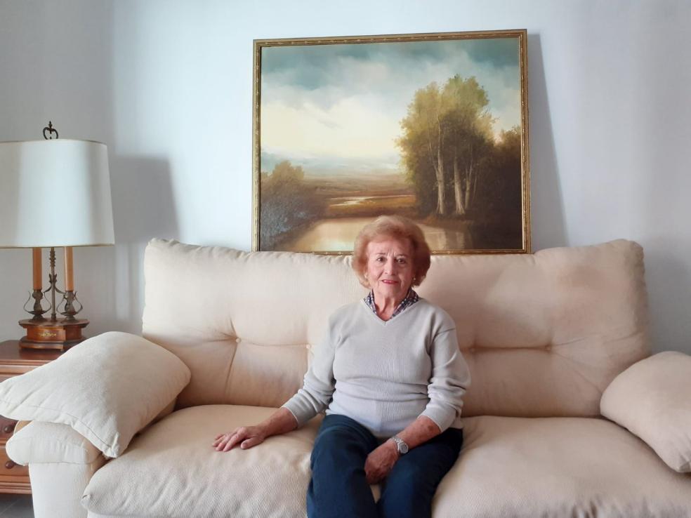  Victoria Mandly in her living room with one of the works of art she took with her to her new home. 
