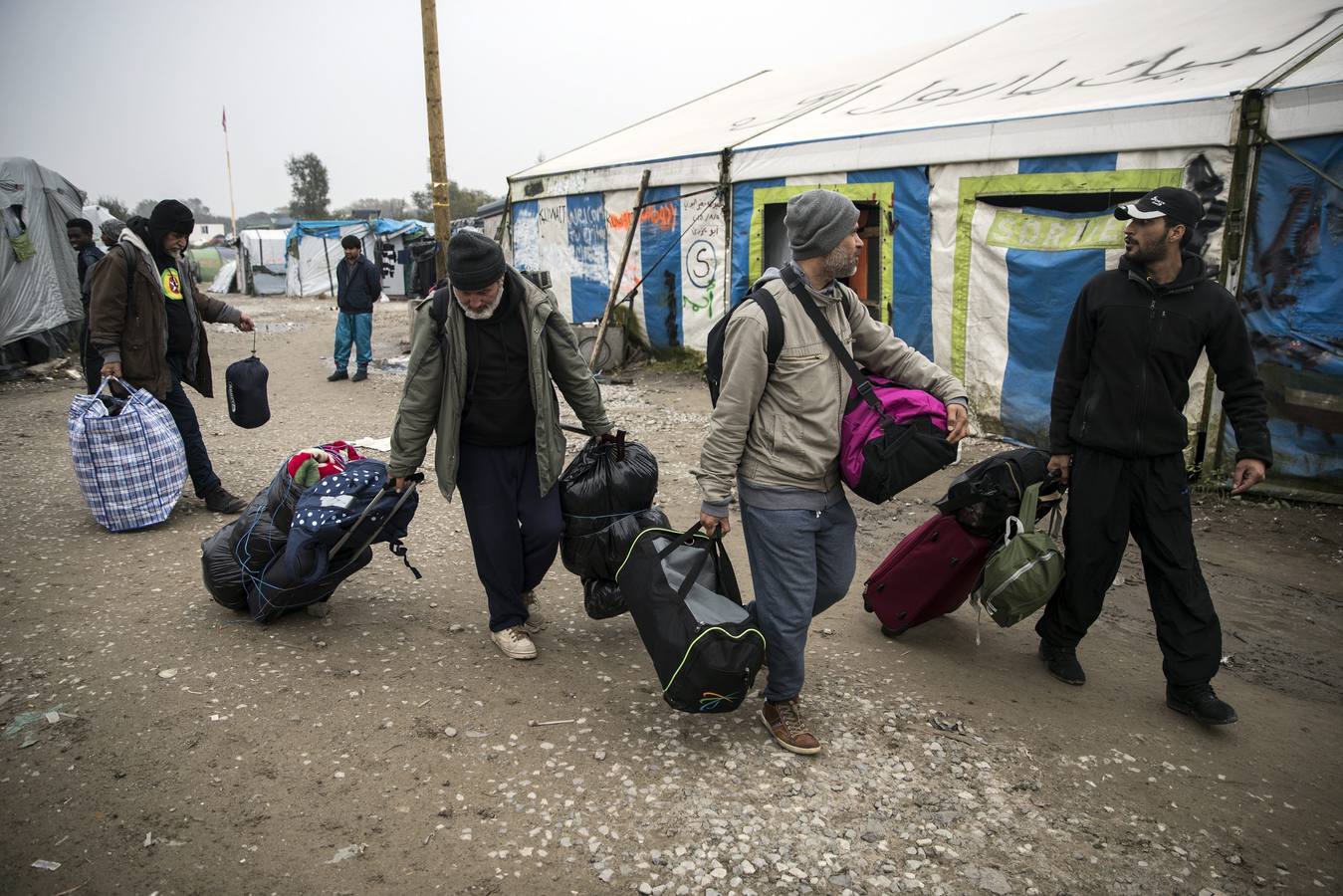 Inmigrantes y refugiados abandonan la 'Jungla' de Calais en el primer día de desalojo