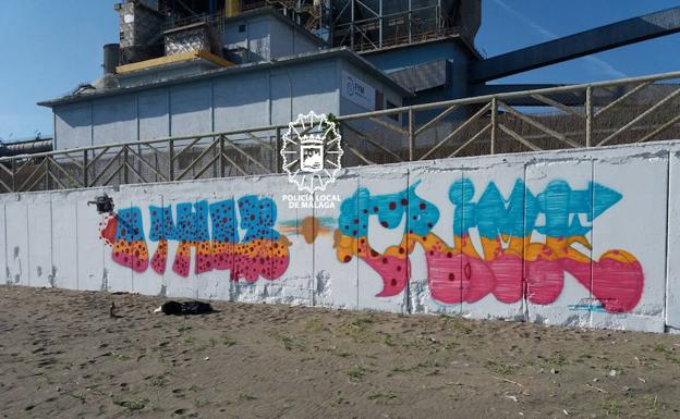 Sorprenden a tres grafiteros pintando un muro en la playa de La Araña