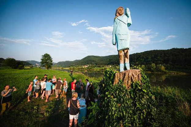 La estatua de Melania Trump está tallada en un tronco; a la izquierda, detalle de la obra que representa a la primera dama el día de la toma de posesión de su marido. :: Jure Makovec / AFP/
