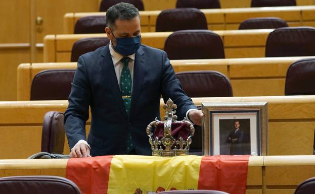 Un senador del PP recibe a Iglesias con bandera, corona y un retrato del Rey