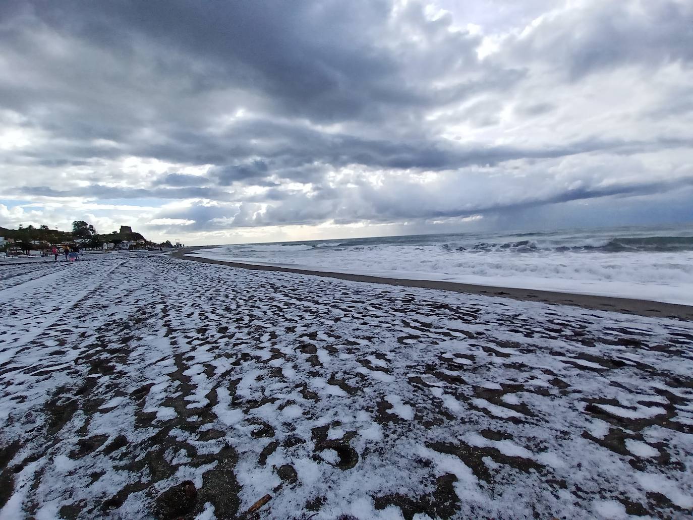 Insólita imagen de la playa de Benajarafe tras la fuerte granizada de esta mañana