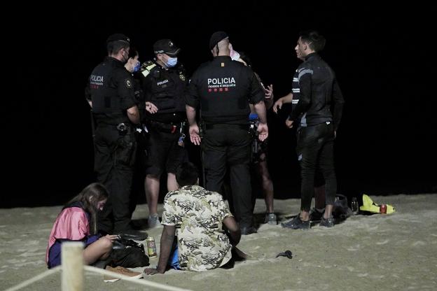Los Mossos y la Guardia Urbana identifican ayer por la noche a varias personas en la playa de Barcelona. efe/